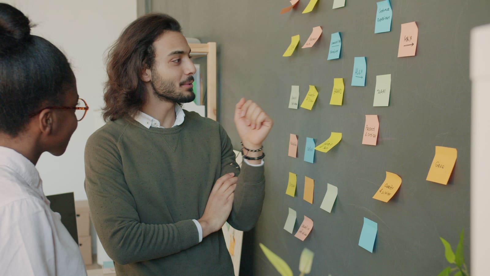 Colleagues engage in active brainstorming session using colorful sticky notes