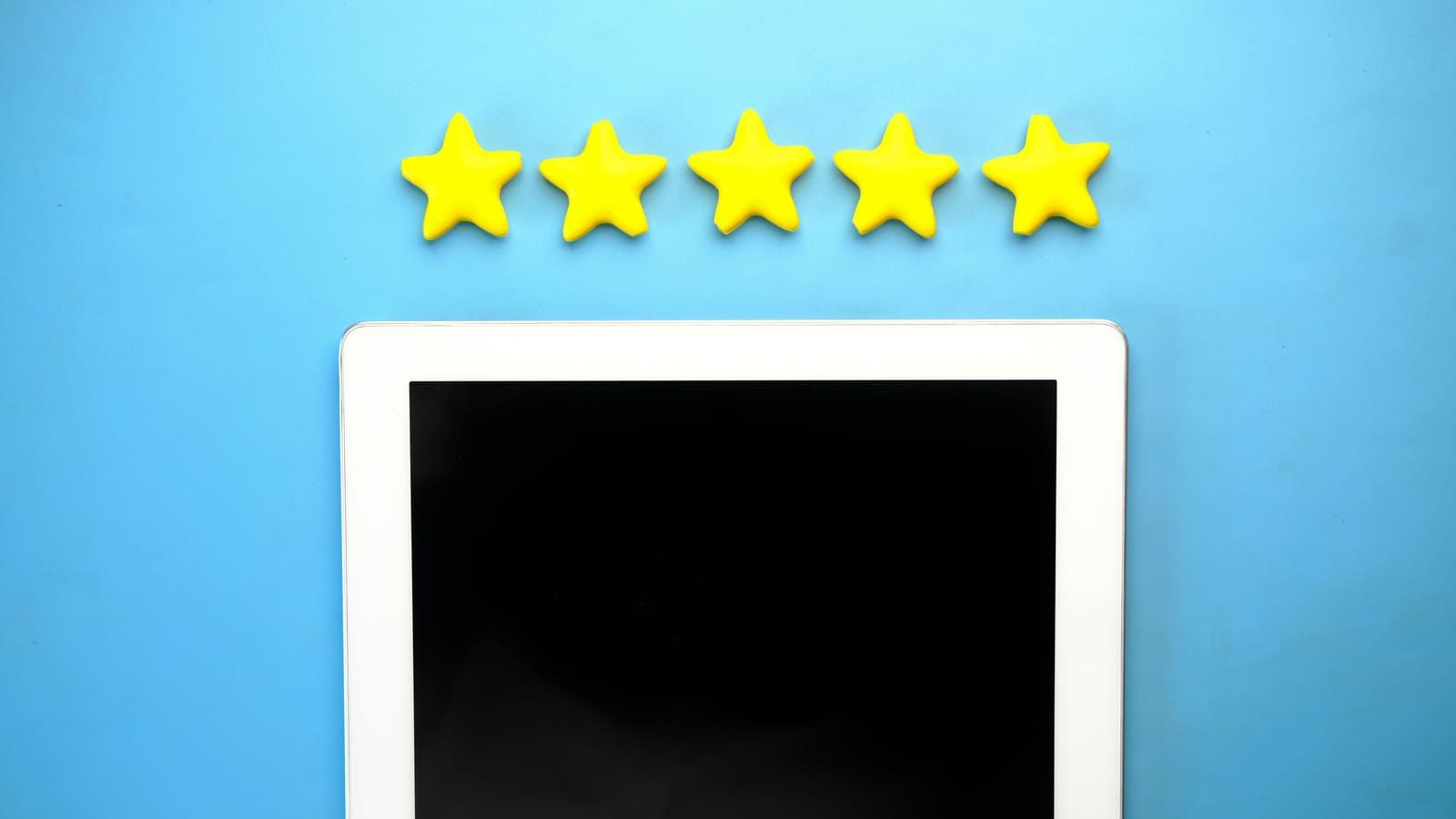 Tablet with five yellow stars on a blue background, ideal for rating concepts