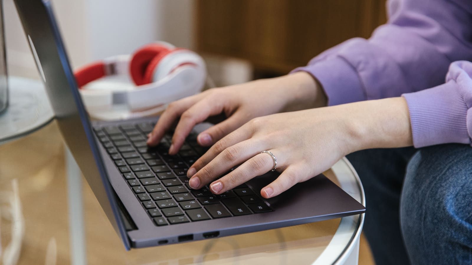 Close-up view of hands typing on a laptop indoors, showcasing technology and productivity